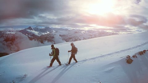 aerial view of two male hikers walking in untouched snow mountain landscape. aventures journey trip scenery of people climbing together on extreme winter expedition tour 