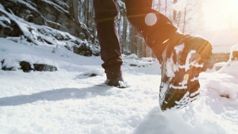 feet walking in deep snow shot in slow motion. foot steps of hiker. recreational winter activity outdoors