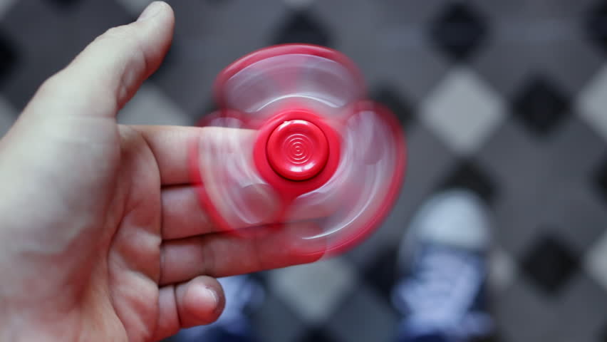 Boy hand playing with red spinner.