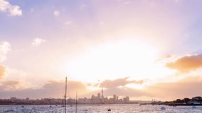 Time lapse of the sunset above Auckland city’s skyline with the harbour, the ocean and some boats at the front