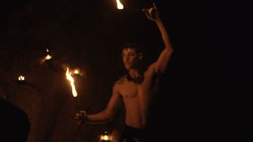 Handsome man doing fires how at the beach - video in slow motion