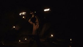 Handsome man doing fires how at the beach - video in slow motion