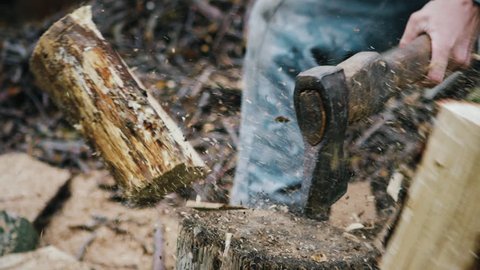 Chopping wood slow motion. Worker chopping wood outdoors