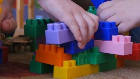 Children play in the designer in kindergarten. Happy kids, teamwork in kindergarten. Children's hands with colored cubes. Childhood preschool education education. Happy dream concept