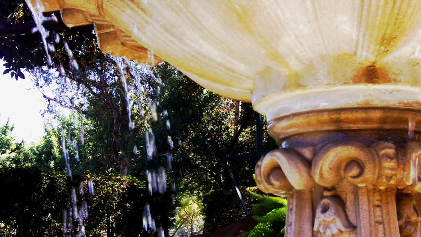 Water gently spills from the lip of a Victorian era fountain evoking a bygone