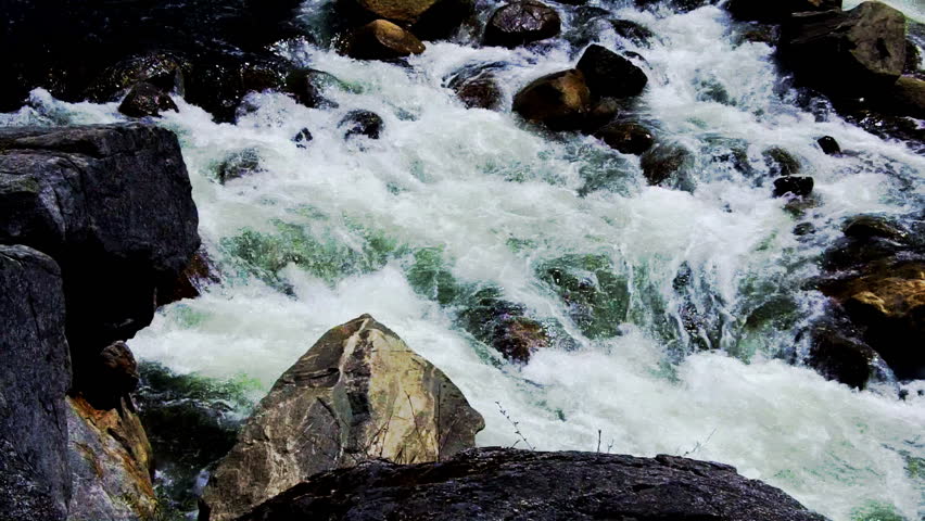 White water rapids foaming over rocks on the Stanislaus river which is a popular