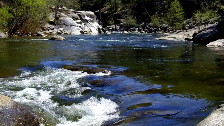 Clear mountain river water spills over rocks on the Stanislaus river which is a