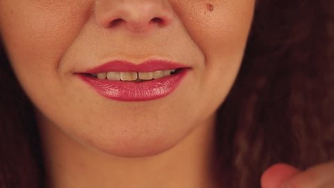 Close up of smiling face of woman with smoky eyes style make-up and yellow teeth as aftersmoking affect. Front view.