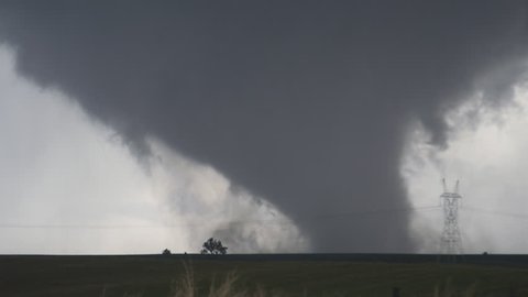 A massive wedge-shaped tornado looms above Nebraska farmland
