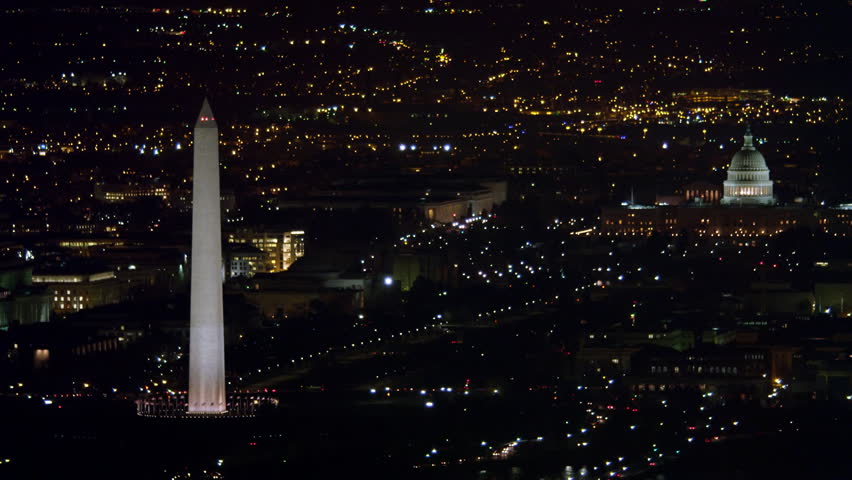 Over Washington DC cityscape at night, Washington Monument and Capitol in distance. Shot in 2011. | Shutterstock HD Video #26876914