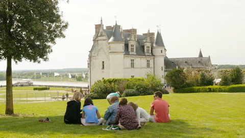AMBOISE, FRANCE - CIRCA 2017: Unique footage of Royal Chateau de Amboise - Loire Valley - Castle of Amboise family having a picnic green grass Amboise castle in the background - advertising cinematic