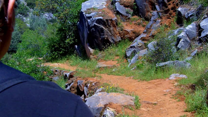 A man walks a narrow and rocky trail in the Sierra Nevada Mountain Foothills in California's "Gold Country" near Sonora, CA. This area is rich in minerals and recreation opportunities.