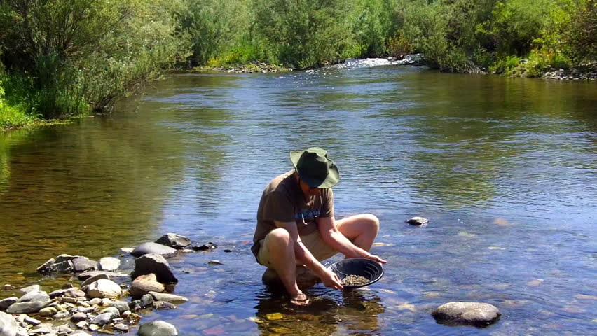 A man pans for gold on the Mokelumne River near San Andrea, CA in the Sierra