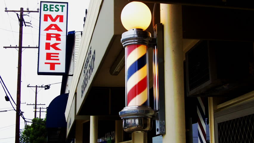 LONG BEACH, CA/USA- August 12 2012: A barber pole and family market sign evoke