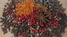 Mix of Red, Black, White and Green Hot Peppers, saffron, carnation, star anise is rotating on wooden background 
Footage will work great for any videos dealing with cooking, travel or ayurveda.  