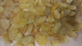 Amber  raisins are on wooden background. Yellow dry raisins are rotating close up.
Footage will work great for any videos dealing with healthy food, healthy lifestyle, dietetics or cooking and baking