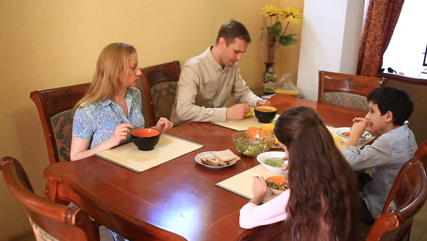 The family dines at home in the dining room. Children teenagers, twins and their parents