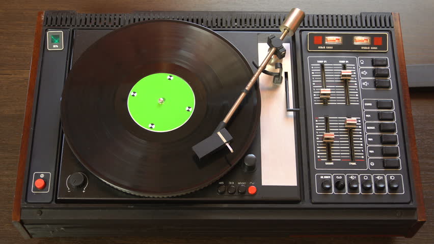 Vinyl record pleer. Plays song from an old turntable 4k top view. Black background. Music round plate rotate. Music disc turn. Tracking shot rotating disk with chroma-key green screen. Tracking point.