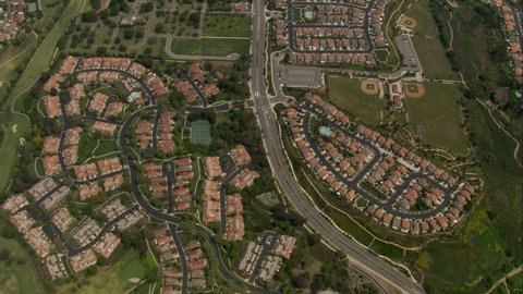 Looking down on a mosaic of homes, many with a pool