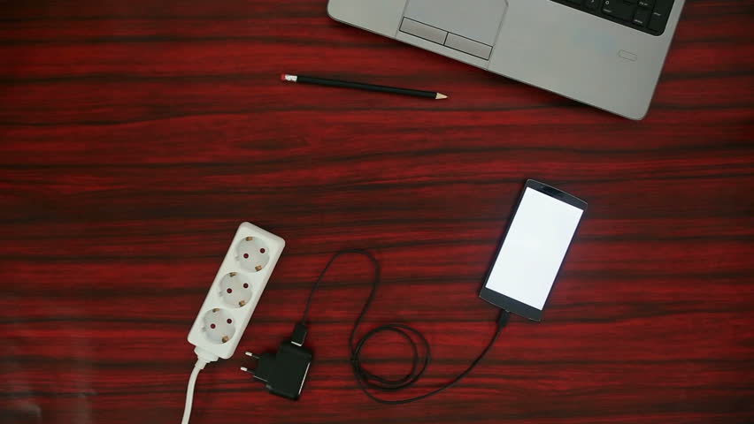 Person connceting smartphone to electric socket on a power strip through a cable and adapter. Royalty-Free Stock Footage #26914975