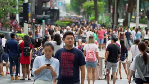 SINGAPORE CITY,SINGAPORE - MAY 13, 2017:TImelapse Crowd of unidentified people cross Orchard Road. Orchard Road is a 2.2 kilometer-long boulevard that is the retail and entertainment hub of Singapore.