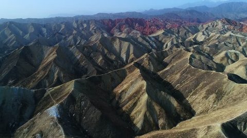 Flying a drone over the colorful Zhangye Rainbow Mountains; aerial view on sandstone hills and mountain chains covered by amazing pattern. Part 3 of a continuous 5 part series-can be merged to 1 movie