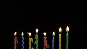 Footage colorful burning candles set on black background. 4k video