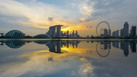 Beautiful Time lapse of Day to Night of Singapore skyline with reflection. 4K UHD. Pan Down Camera Motion.