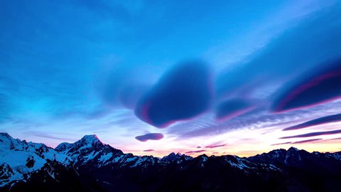 Time lapse of lenticular clouds paint in pink in motion at the sunset above the snowy summit of mount Cook the aoraki mount cook national park in the south island of New Zealand