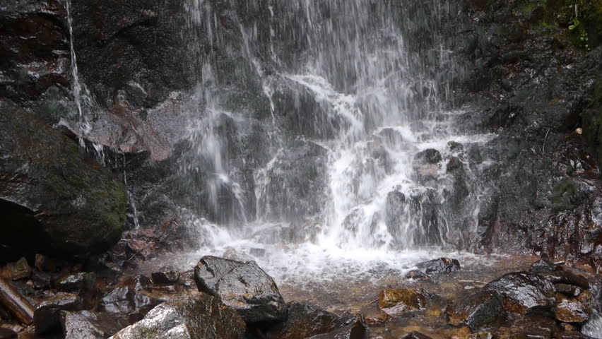 Cascade or waterfall with black rocks.