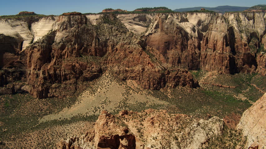 Close past scarred desert mountaintops capped with trees in Zion National Park, Utah. Shot in June 2013.