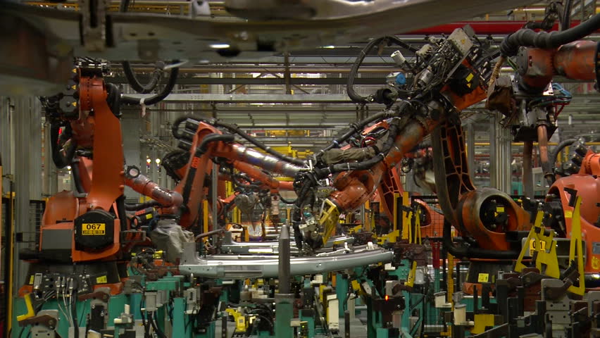 Robots are welding metal in car factory