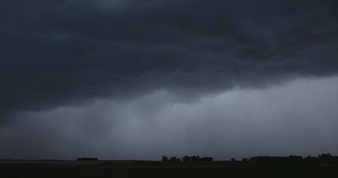 Thunderstorm with lightning pours rain onto darkened North Dakota farmland
