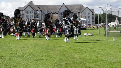 NAIRN, SCOTLAND - AUGUST 18: Massed pipe bands marching at the Highland Games in Nairn, Scotland on August 18, 2012. Highland games events are a popular tourist attraction during the Scottish summer.