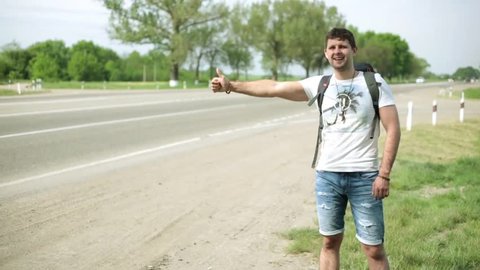 Hitchhiking along the road. A man hitchhiking on the highway.