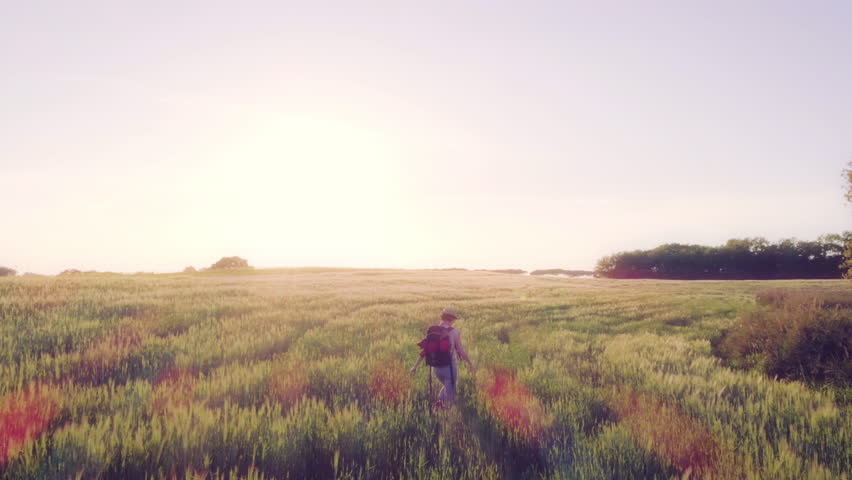 Woman with Backpack walking through farm fields