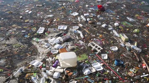 Plastic bottles and other trash floating in polluted ocean