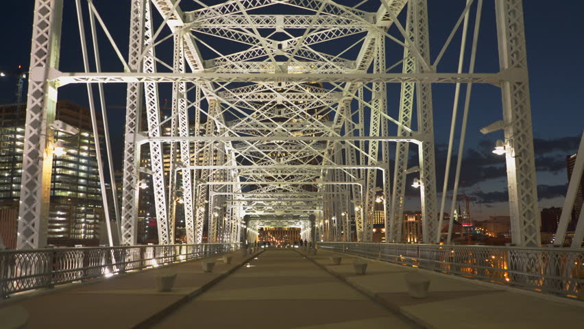 a three axis gimbal shot walking across shelby st pedestrian bridge in nashville, tennesse at night