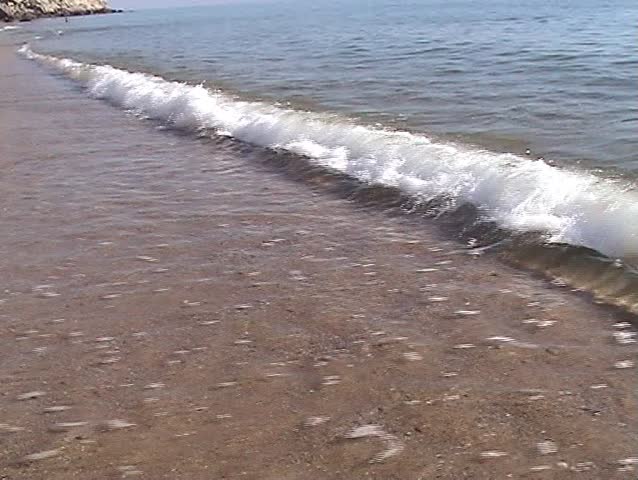 Woman walking in the waves of the beach