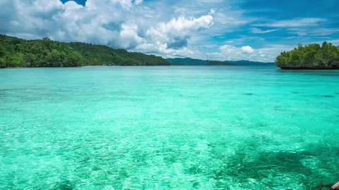 Beautiful blue lagoon with pure clear water and rainy clouds in background, Gam Island, West Papua, Raja Ampat, Indonesia