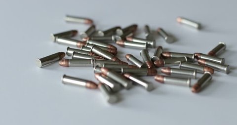 Scattered .22 bullet shells on a white surface
