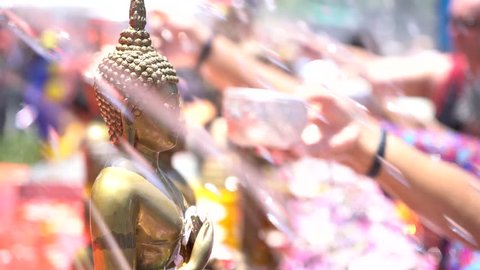 Slow motion Shower the monk sculpture with Songkran festival Thailand
