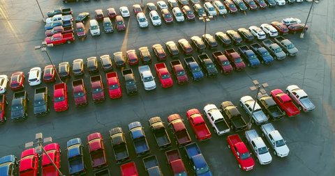 New car dealership lot, many vehicles for sale, aerial view.
