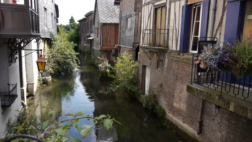 Old street in Pont Audemer France wih a small flowing river