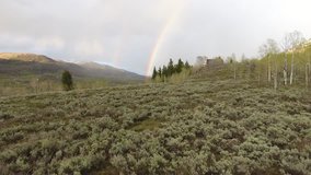 Beautiful mountain scenery after a rain storm in spring time and a rainbow in the sky.