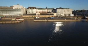 Aerial view drone footage of Helsinki old market square area and 19-century market hall near sea terminal and harbour with city skyline and Baltic Sea view in the capital of Finland, northern Europe