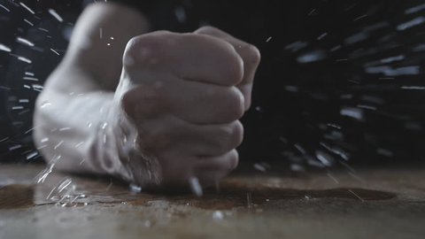 The man beats his fist on the wet table showing aggression. Concept of cruelty.