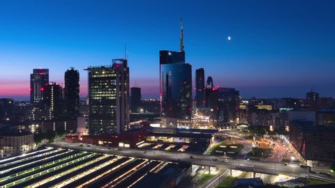 milan timelapse from night to day traffic running under skyscrapers