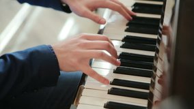 pianist in blue suit plays rapidly on the piano. top view, close up, slow motion.