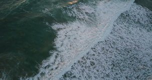 Aerial video. Waves breaking in the Atlantic ocean at sunset. 